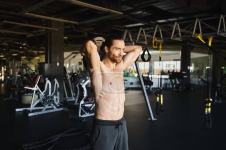 Ein muskulöser Mann ohne Hemd trainiert in einem Fitnessstudio.
