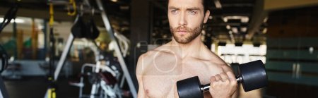 A shirtless man showcasing his muscular physique while holding dumbbell in a gym.