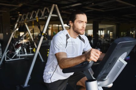 Foto de Un hombre musculoso haciendo ejercicio en una bicicleta estacionaria en un gimnasio, centrándose en mejorar su condición física y resistencia. - Imagen libre de derechos