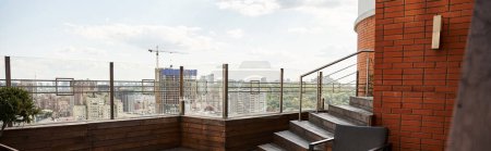 Téléchargez les photos : Un balcon paisible encadré par un mur de briques texturé et une élégante balustrade en métal, offrant un espace serein avec une touche de charme - en image libre de droit