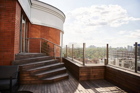 Téléchargez les photos : Un balcon offre une vue imprenable sur le paysage urbain ci-dessous, mettant en valeur la vie urbaine animée et les gratte-ciel imposants. - en image libre de droit
