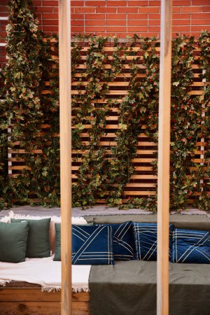 Un canapé en peluche repose devant un mur de briques texturé, créant un coin salon confortable et accueillant dans un cadre rustique