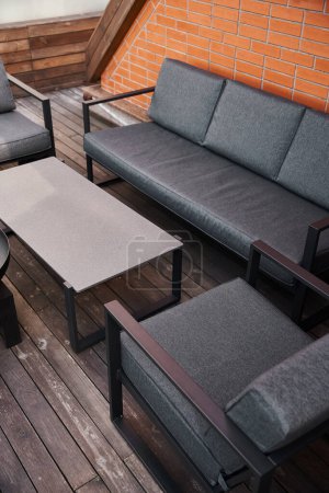 Téléchargez les photos : Un canapé confortable et des chaises placées sur un sol en bois poli, créant un coin salon accueillant et élégant dans une chambre - en image libre de droit
