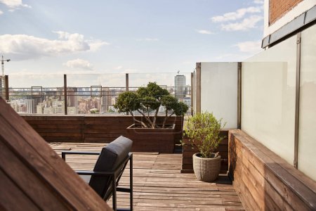 Téléchargez les photos : Une terrasse en bois ornée d'une chaise et de plantes en pot, créant un espace extérieur paisible et paisible - en image libre de droit