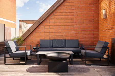 Téléchargez les photos : Une installation confortable d'un canapé et des chaises sur une terrasse en bois, en pleine nature, parfait pour se détendre ou se divertir à l'extérieur - en image libre de droit