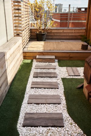 Une arrière-cour paisible avec une terrasse en bois et un charmant jardin rempli de fleurs vibrantes et de verdure