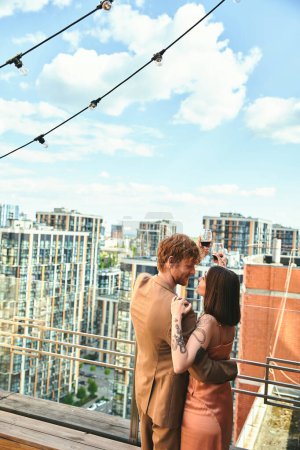 Un hombre y una mujer de pie en un balcón con vistas al paisaje urbano, perdidos en un momento romántico mientras escuchan la música de la noche