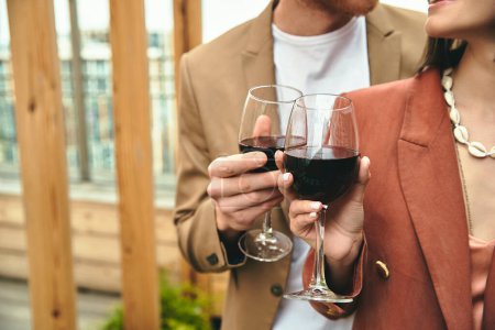 Téléchargez les photos : Un homme et une femme serrent joyeusement des verres à vin dans un cadre romantique et clair de lune - en image libre de droit