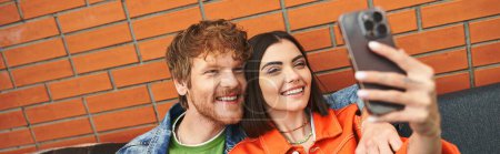 Homme et femme souriant, posant et utilisant un téléphone portable pour prendre un selfie ensemble dans un moment joyeux de connexion et de compagnie