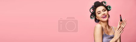 Photo for A woman holding a lipstick in front of her face. - Royalty Free Image