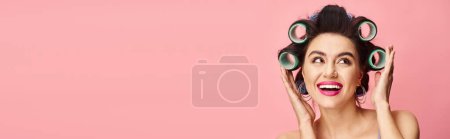 Téléchargez les photos : Une femme avec des bigoudis tenant ses cheveux, présentant un style sans effort. - en image libre de droit