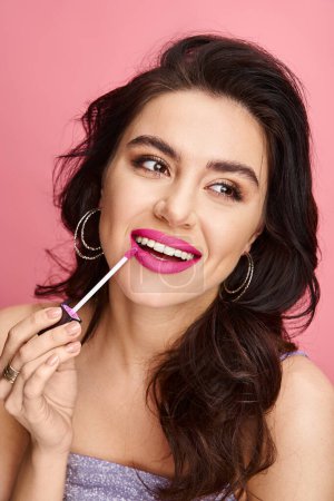 Una hermosa mujer con belleza natural exhibe lápiz labial rosa en sus labios contra un vibrante telón de fondo.