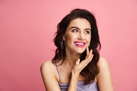 Photo for A gorgeous woman poses in front of a bright pink backdrop. - Royalty Free Image