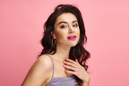 A natural beauty woman with long dark hair and pink lipstick posing on a vibrant backdrop.