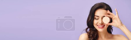 Photo for A beautiful woman holding a cream to her face, enhancing her natural beauty. - Royalty Free Image