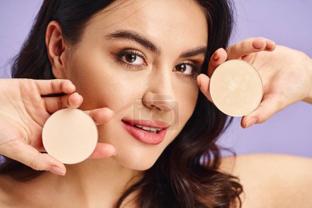 Téléchargez les photos : Une femme tenant une crème devant son visage, appliquant du maquillage. - en image libre de droit