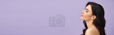 Téléchargez les photos : Femme aux longs cheveux noirs se tenant élégamment contre un mur violet. - en image libre de droit