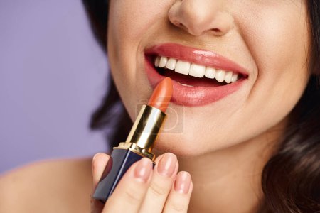 A beautiful woman enhancing her appearance by applying lipstick to her lips.