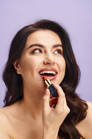 A beautiful woman enhancing her natural beauty by applying lipstick to her lips.