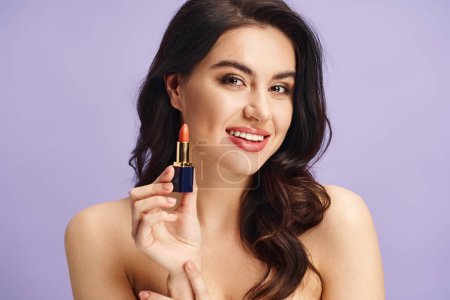 A woman gracefully holds a lipstick, enhancing her natural beauty.
