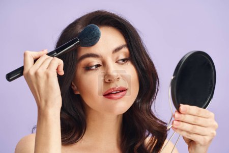 A woman holding a brush and a mirror, applying makeup.