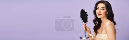 Photo for Woman in white dress applies makeup, holding mirror. - Royalty Free Image