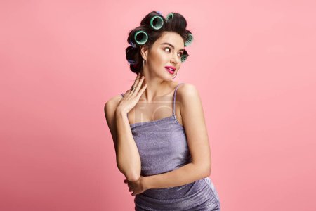 Eine stilvolle Frau mit Lockenwicklern im Haar posiert.