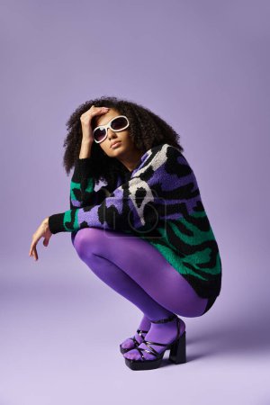 A young woman striking a pose in purple pants and a zebra-patterned sweater against a purple backdrop.