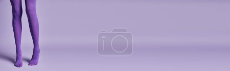 Un mannequin violet se tient gracieusement devant un fond violet profond, créant une scène captivante et mystérieuse.