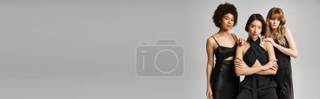 Photo for A group of elegant caucasian, Asian, and African American women standing together on a grey studio background. - Royalty Free Image