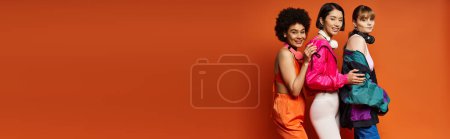 Photo for A group of diverse women standing close together, showcasing unity and beauty against an orange studio background. - Royalty Free Image