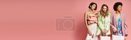 Photo for A group of beautiful women of different ethnicities standing together in front of a pink background. - Royalty Free Image