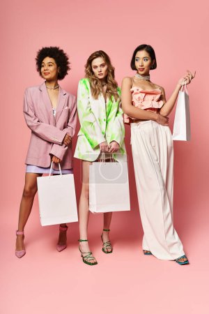 Diverse group of women standing together with shopping bags against a pink background.