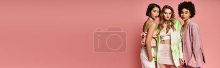 Photo for A beautiful group of women, representing diversity, stand together against a pink background in a studio setting. - Royalty Free Image