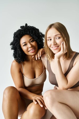 Photo for Two diverse women in cozy pastel underwear posing for a picture. - Royalty Free Image