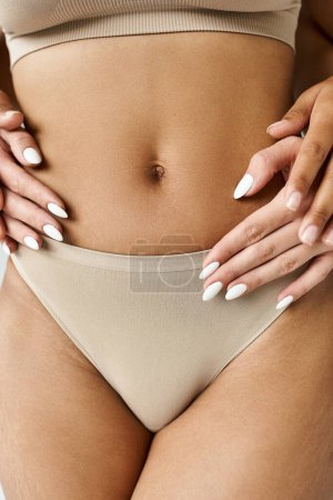 Foto de Una mujer posando con confianza con las manos en las caderas mostrando su estómago. - Imagen libre de derechos