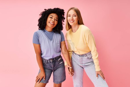 Photo for Two stylish women standing elegantly on a pink background. - Royalty Free Image