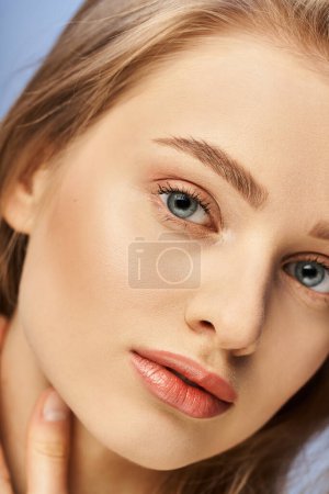 Una joven rubia con ojos azules llamativos, de cerca y cautivadora.
