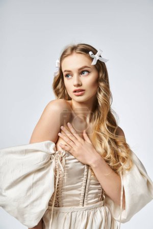 A young blonde woman with a bow in her hair radiates beauty and elegance in a white dress.