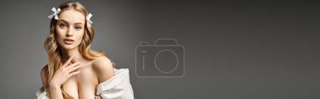 Téléchargez les photos : Une superbe jeune femme blonde pose élégamment dans une robe blanche dans un décor de studio. - en image libre de droit