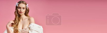 Téléchargez les photos : Une superbe jeune femme aux longs cheveux blonds pose élégamment dans une robe blanche dans un décor de studio. - en image libre de droit