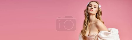 Téléchargez les photos : Une jeune femme blonde pose gracieusement en robe blanche dans un décor de studio. - en image libre de droit