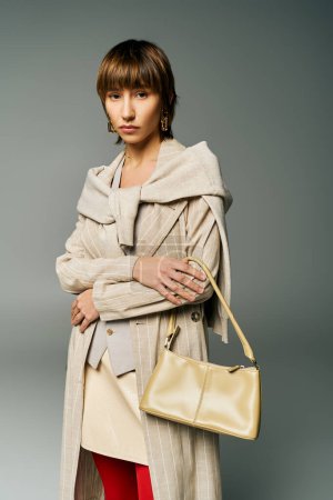 A stylish young woman with short hair holding a purse strikes a pose in a studio setting.