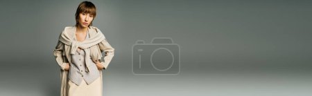 Téléchargez les photos : Une jeune femme aux cheveux courts pose dans une robe longue et fluide et une écharpe dans un décor studio. - en image libre de droit