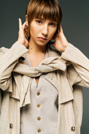 Une jeune femme dans un studio portant une écharpe élégante autour du cou, exsudant grâce et beauté.