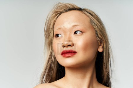 Téléchargez les photos : Une jolie femme asiatique aux cheveux longs et au rouge à lèvres pose avec confiance en tenue vibrante. - en image libre de droit