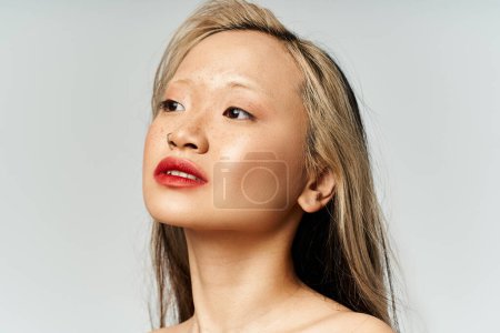 Eine verführerische Asiatin mit langen Haaren und rotem Lippenstift posiert in lebendiger Kleidung.