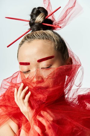 Foto de Mujer asiática con un vestido rojo, los ojos cerrados en pose serena. - Imagen libre de derechos