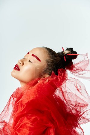 Asian woman with red makeup and a veil on her head poses with vibrancy.