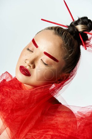 Foto de Mujer asiática vibrante en vestido rojo, ojos cerrados. - Imagen libre de derechos